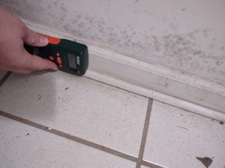 Professional technician safely removing black mold with protective equipment