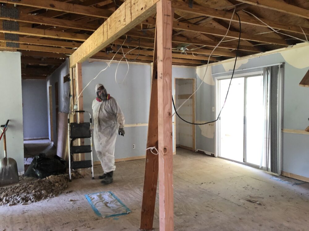 Certified biohazard cleanup team in PPE suits conducting drug lab decontamination safely.