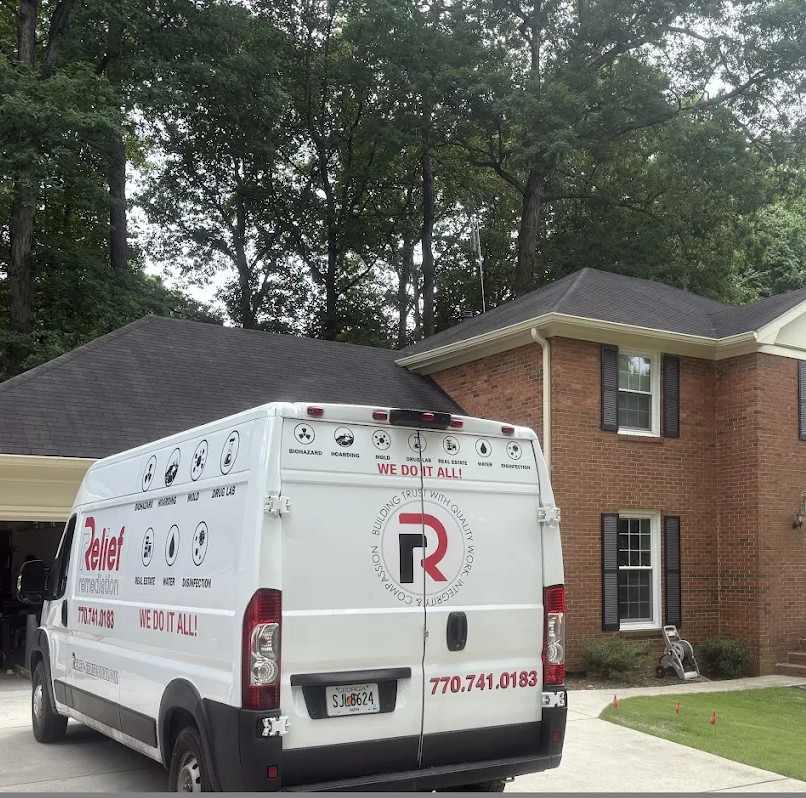 Relief Remediation Ram ProMaster service van parked in driveway at Weatherstone Pkwy, Marietta GA 30068 in front of two-story brick traditional home. IICRC-certified water damage and mold remediation in progress.